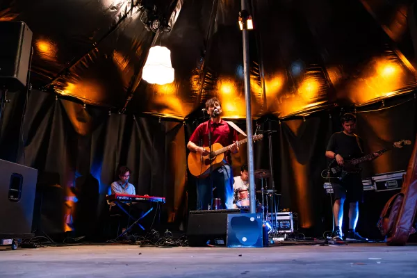 muziekband op een podium in een donkere tent