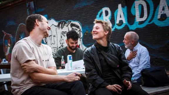 mensen die aan een bankje aan het praten en lachen zijn